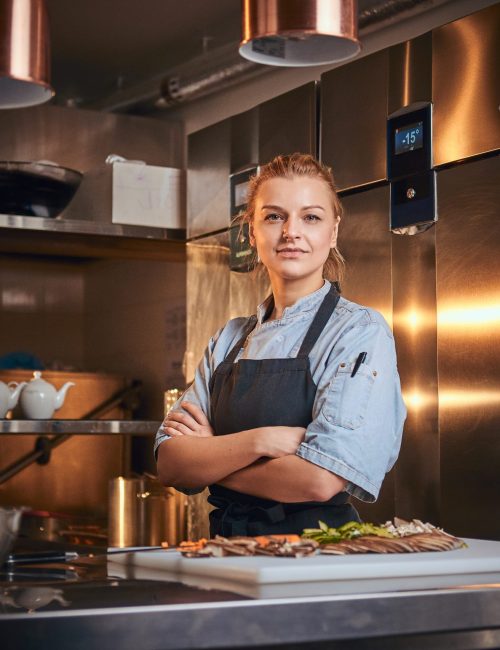 Confident,And,Serious,Female,Chef,Standing,With,Hands,Crossed,In