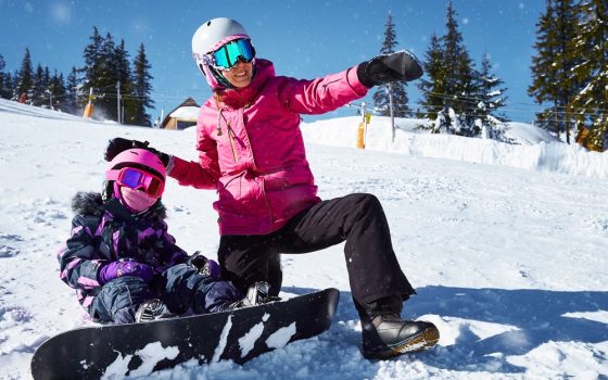 Mother,Teaches,His,Daughter,To,Snowboard.,Woman,Sits,And,Showing